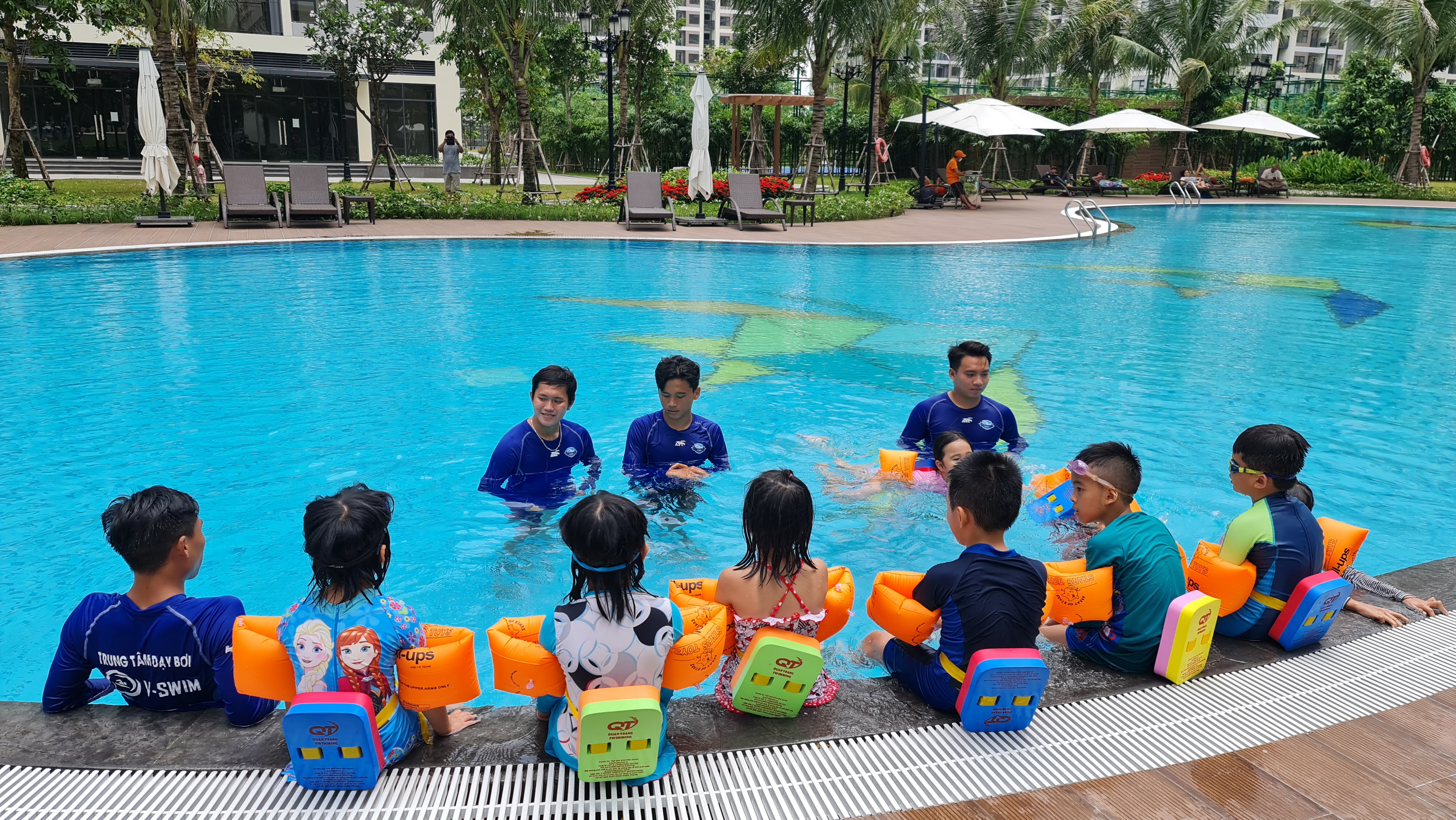 Khởi động và tập làm quen trên thành bể trước khi xuống nước học bơi
