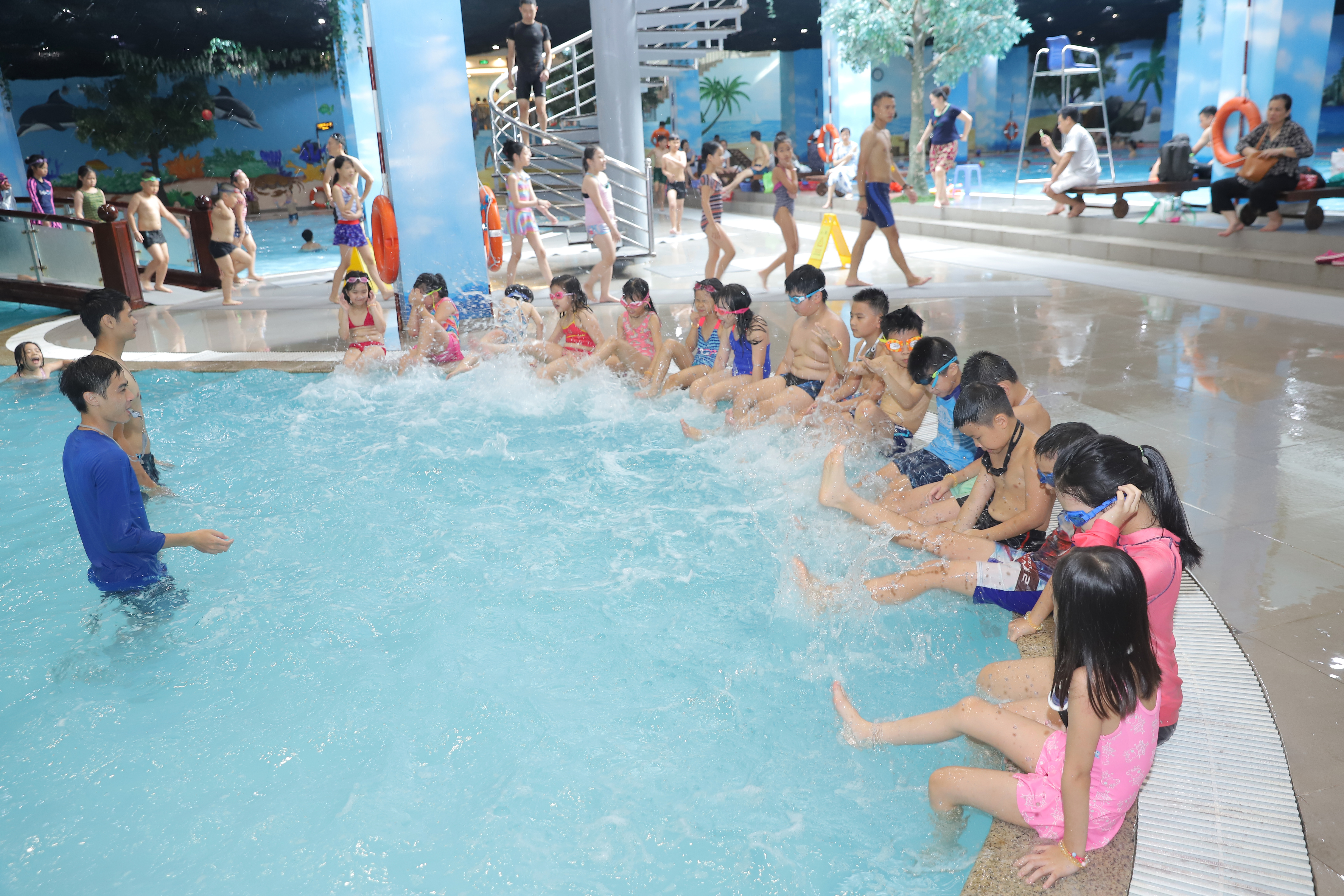 Học viên khởi động trên thành bể trước buổi học bơi tại bể bơi Hà Nội